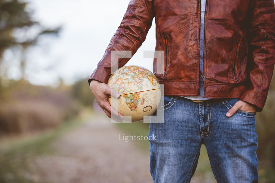 man holding a globe outdoors 