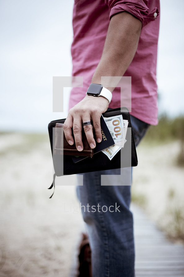 man carrying a Bible, cash, and passport 