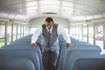 a pastor praying on a church bus 