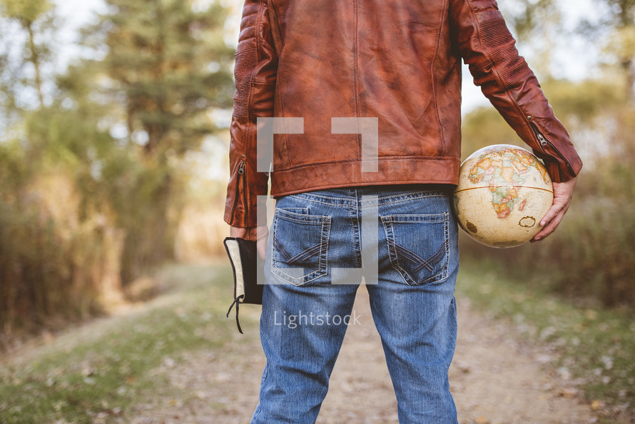 man holding a globe and Bible 