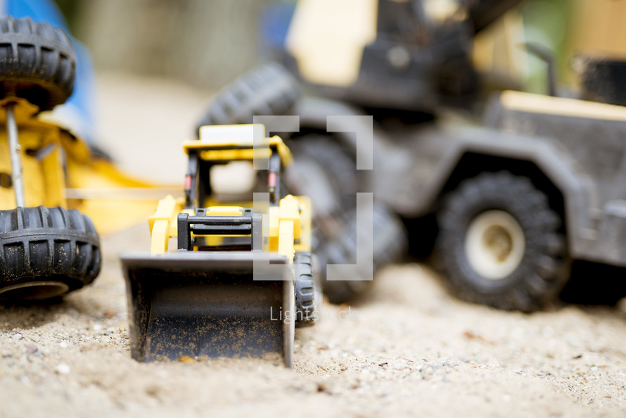 toy trucks in a sandbox 