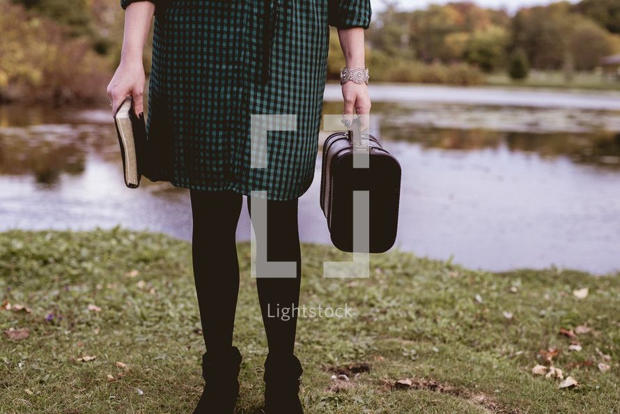 a woman with a Bible and suitcase 