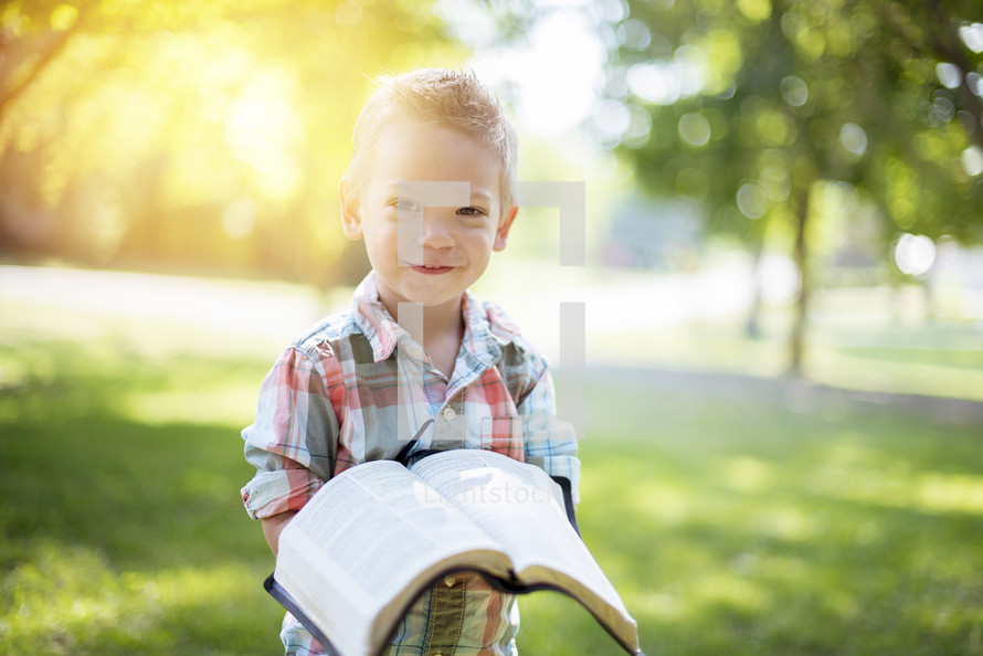toddler boy holding a Bible 