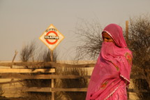 woman wrapped in a scarf standing in a desert