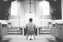 a man kneeling in front of an altar 