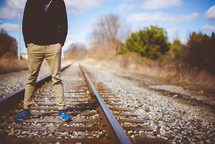 a man standing in the middle of train tracks 