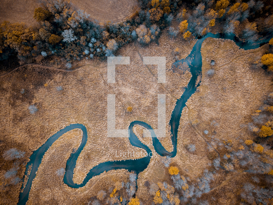 aerial view over a river and fall trees
