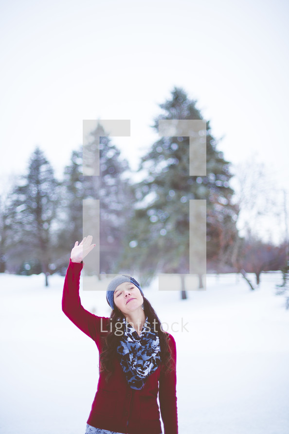 a woman praising God outdoors in winter 