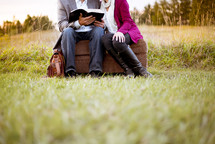 couple reading a Bible together outdoors 