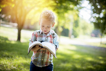 toddler boy holding a Bible 