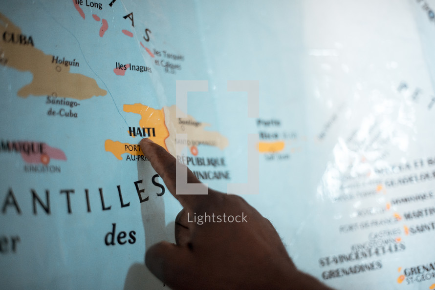 pointing a finger to Haiti on a map 