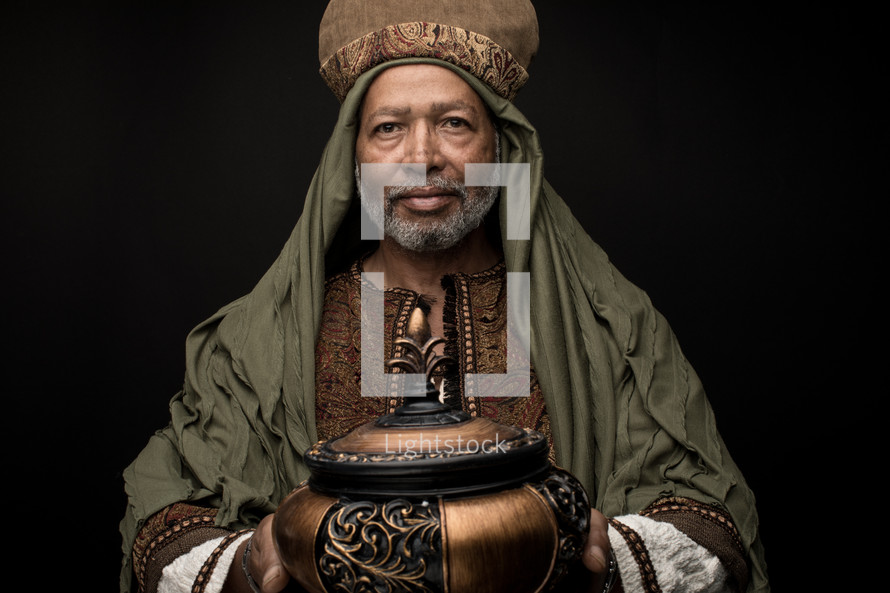 a wiseman holding a gift of frankincense 