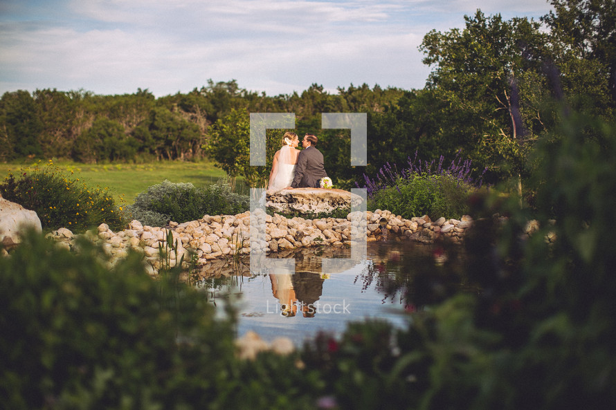 bride and groom in front of a fountain 