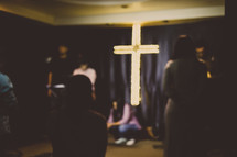 glowing cross and worshipers at a worship service 
