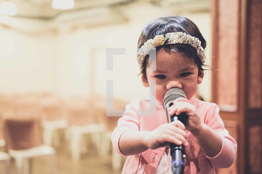 toddler girl holding a microphone 