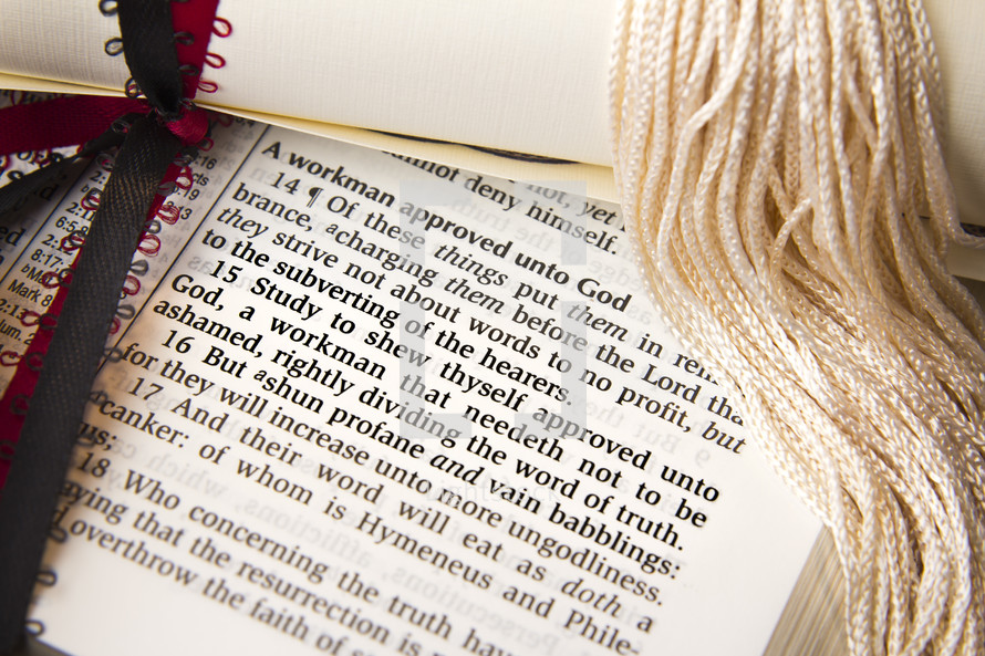 diploma and tassel on the pages of a Bible