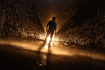 man standing in a glowing and wet tunnel 