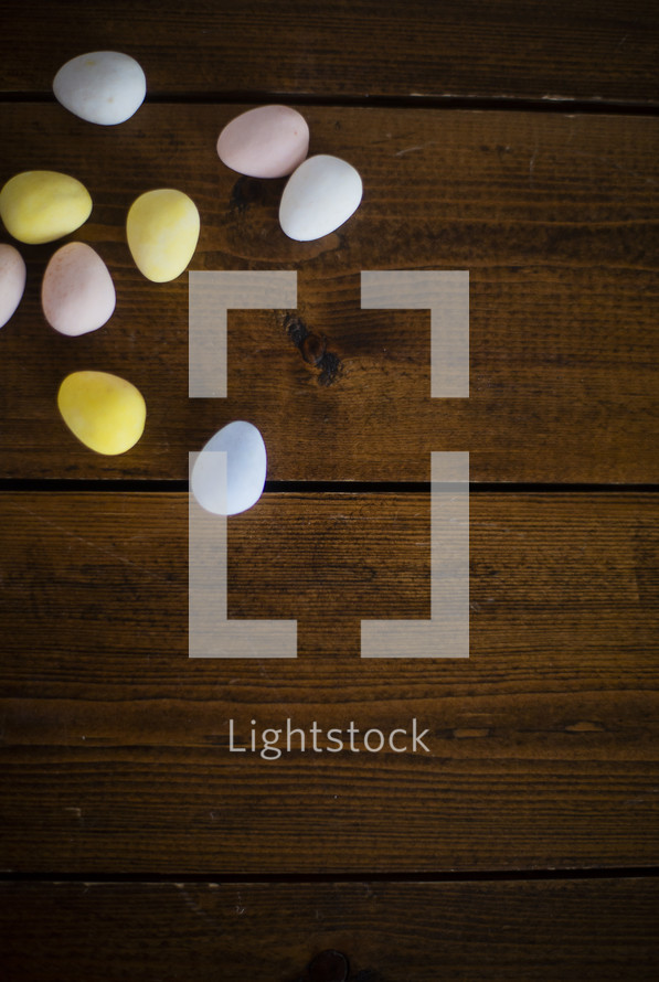 candy Easter eggs on a wood background 