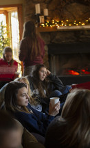 young sitting on a couch in front of a fire talking 