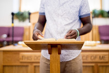 man reading a Bible at the pulpit 