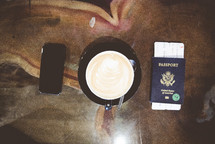passport, plane ticket, cellphone, and coffee cup 