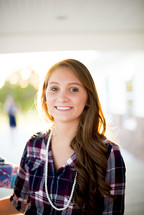 smiling young woman in a plaid shirt 