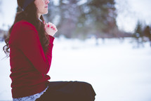 a woman praying outdoors in winter 