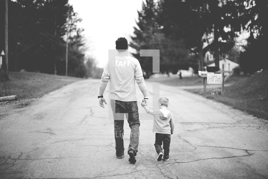 father and son walking holding hands 