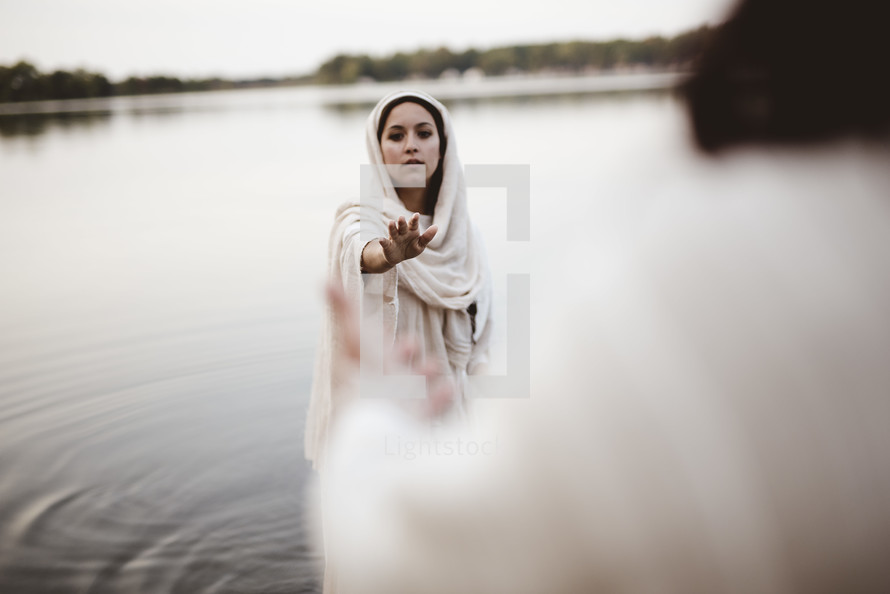 Jesus standing in water reaching towards a woman 