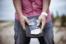 man holding passport, cash, and Bible 
