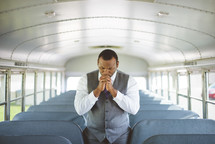 a pastor praying on a church bus 