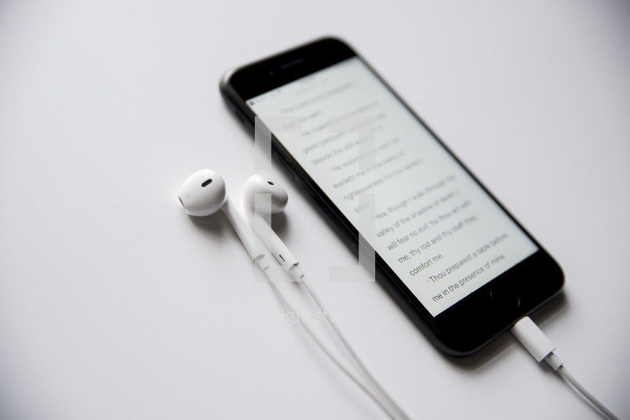 earbuds and Bible app on a cellphone screen 