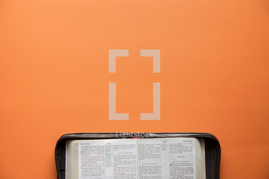 opened Bible on an orange background 