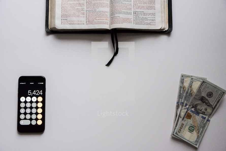 money, calculator, and opened Bible 