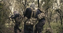 Squad of terrorists walking through a forest scenery