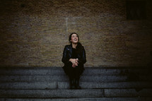 a smiling woman sitting on steps 