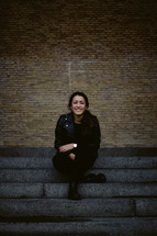 portrait of a smiling woman sitting on steps 