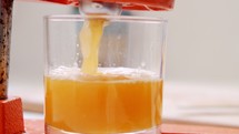 Super slow motion of fresh orange juice squeezed using a manual squeezer