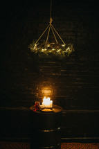 a hanging wreath over a table with candles wine and bread