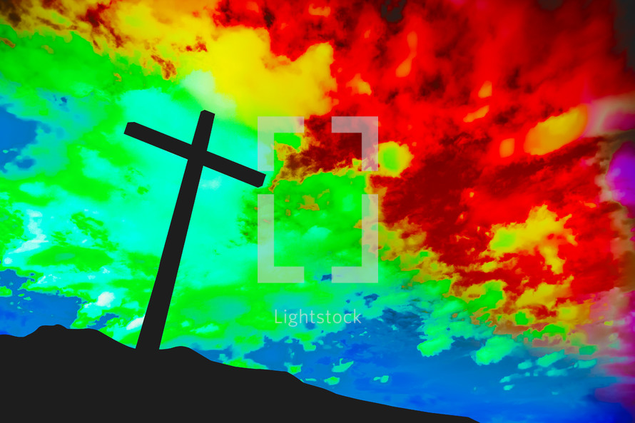 silhouette of a cross under a rainbow sky 