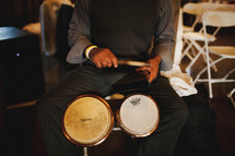 drummer holding drum sticks in his lap