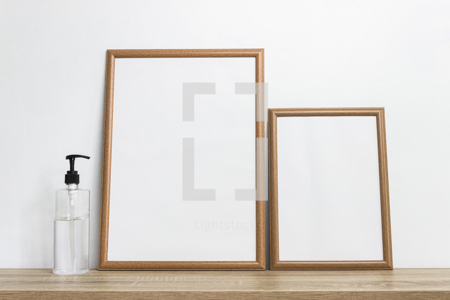 two blank frames and hand sanitizer 