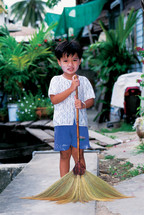 little Thai boy with a broom