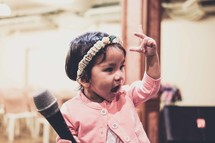 toddler girl holding a microphone 