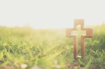 wooden cross in green grass 