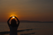a woman holding up her hands in the shape of a heart 