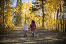 children walking outdoors on a dirt road in fall 