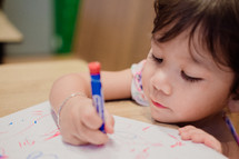 toddler girl coloring with crayons 