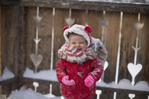 a toddler girl in a winter coat playing in snow 