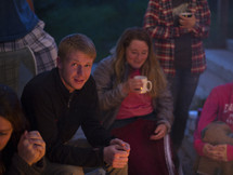friends sitting around a fire drinking hot cider 